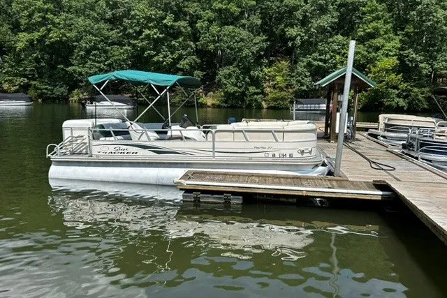 The Image of 2004 Sun Tracker Party Barge 22 I/O Regency Edition docked on a serene lake. - 2