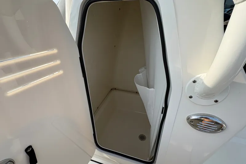 Slide: The Image of 2027 Pioneer 220 Bay Sport boat storage compartment with open door. - 27