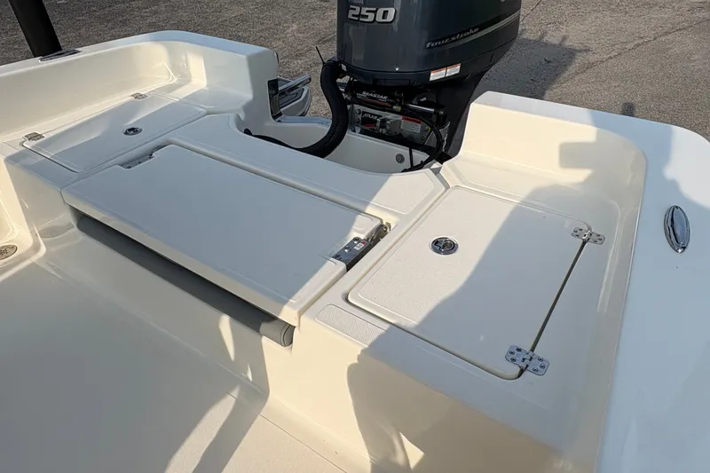 Slide: The Image of 2027 Pioneer 220 Bay Sport boat deck with outboard motor and storage compartments. - 13