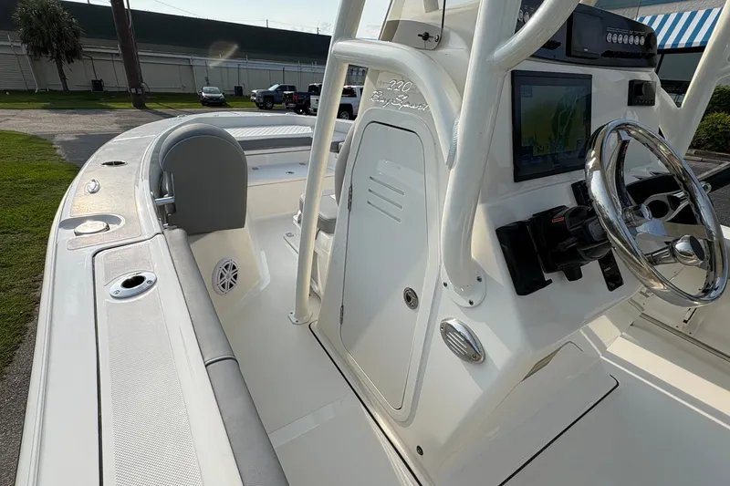 Slide: The Image of 2027 Pioneer 220 Bay Sport boat interior with steering wheel and navigation display. - 26