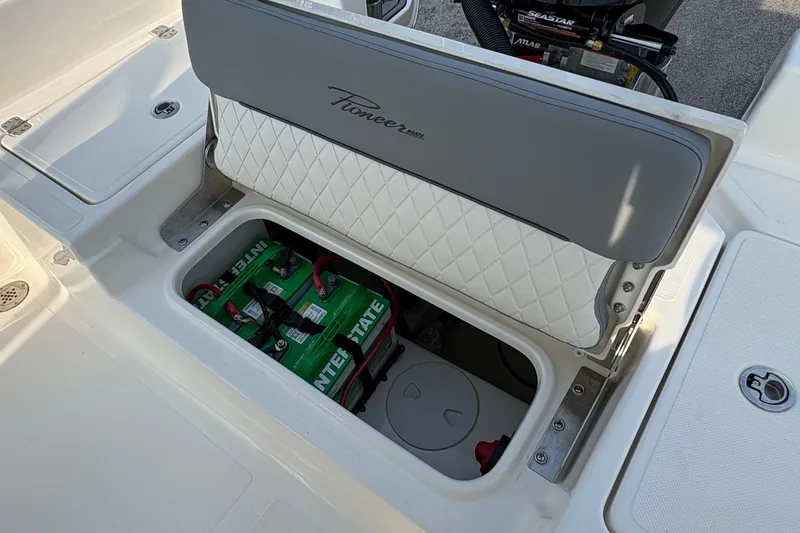 Slide: The Image of 2027 Pioneer 220 Bay Sport boat battery compartment with Interstate battery visible. - 12