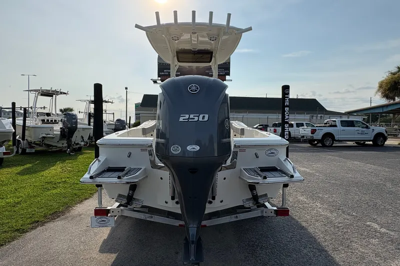 Slide: The Image of 2027 Pioneer 220 Bay Sport boat with Yamaha 250 engine, parked outdoors. - 2