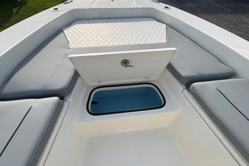 Slide: The Image of 2027 Pioneer 220 Bay Sport boat interior with open storage compartment and cushioned seating. - 29