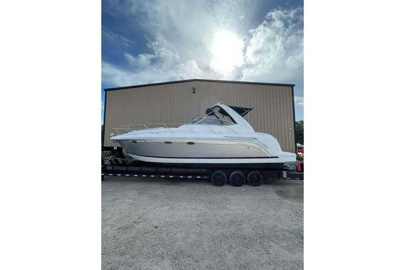 The Image of 2004 Formula 34 Performance Cruiser on trailer, parked outdoors under a cloudy sky. - 1