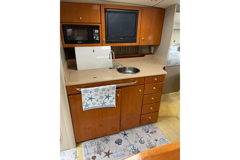 Slide: The Image of 2004 Formula 34 Performance Cruiser kitchen with microwave, sink, and wooden cabinetry. - 21