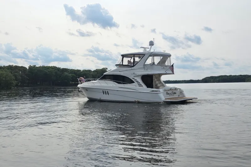 Slide: The Image of 2008 Silverton 52 Ovation yacht cruising on a serene lake under a cloudy sky. - 3
