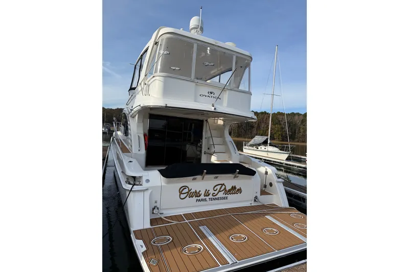 Slide: The Image of 2008 Silverton 52 Ovation yacht docked, featuring spacious deck and elegant design. - 9