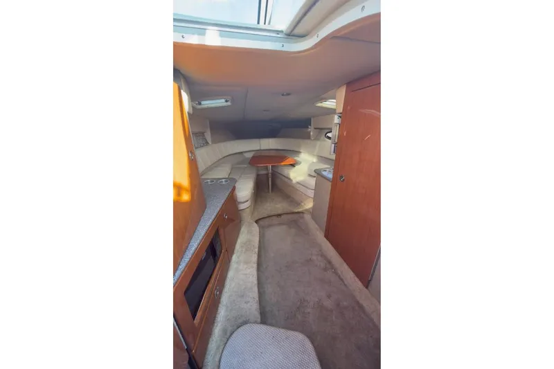 Slide: The Image of Interior of 2005 Formula 330 Sun Sport boat with cozy seating and wooden cabinetry. - 2