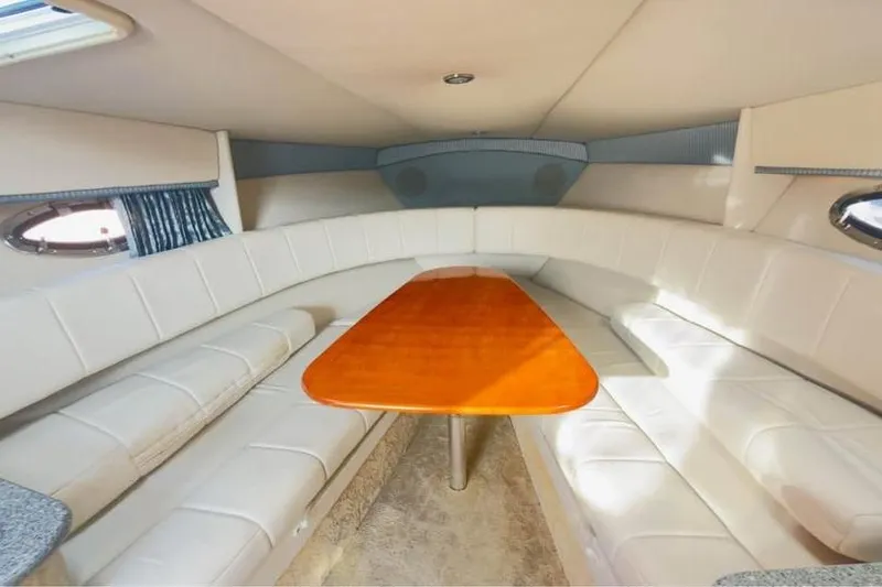 Slide: The Image of 2005 Formula 330 Sun Sport cabin with white seating and wooden table. - 4