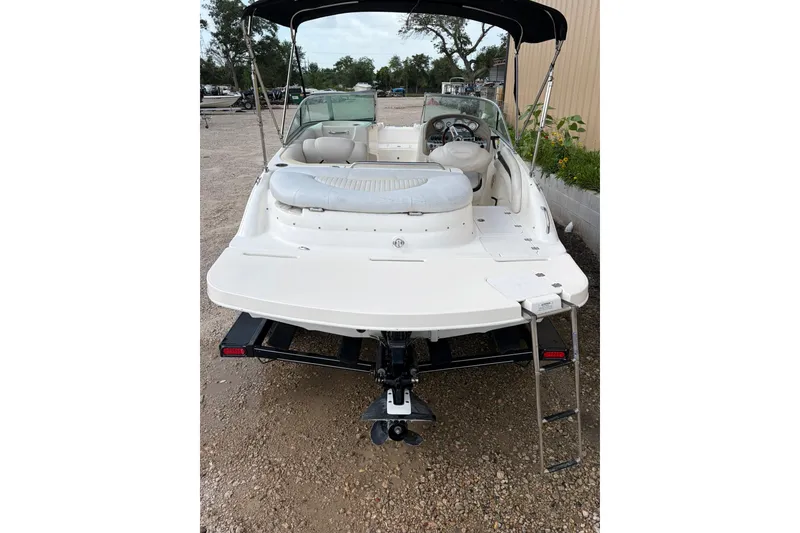 Slide: The Image of 2009 Mastercraft X-45 boat with seating, ladder, and canopy, parked on gravel. - 21