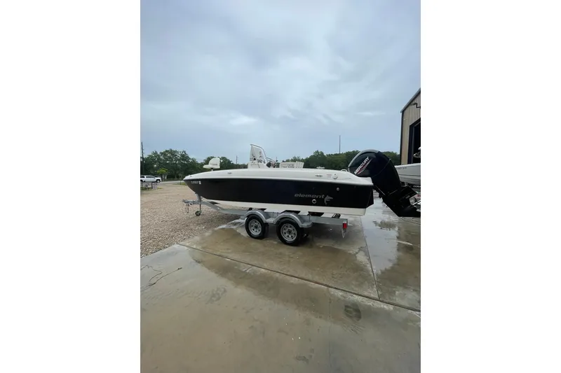Slide: The Image of 2021 Bayliner Element F21 boat on trailer, parked outdoors on a cloudy day. - 5