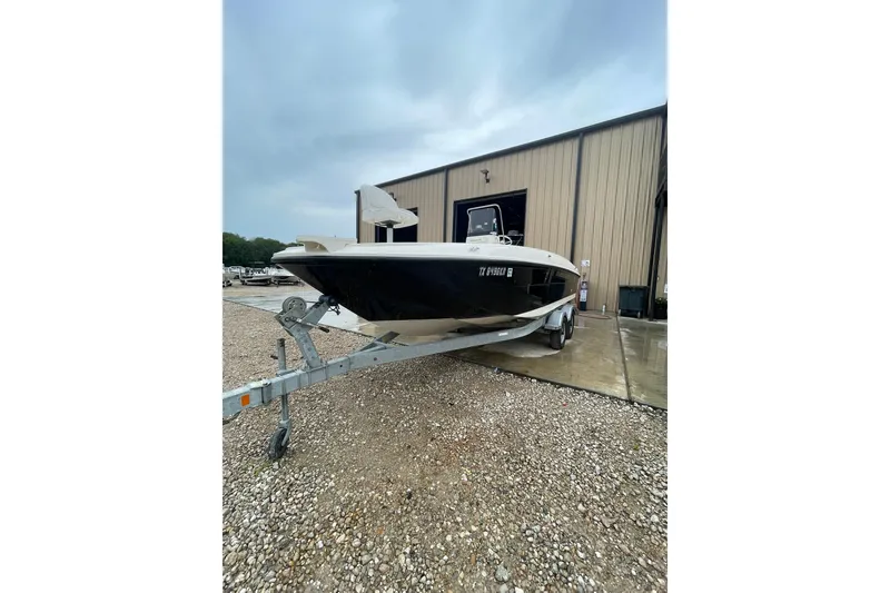 Slide: The Image of 2021 Bayliner Element F21 boat on trailer outside a warehouse. - 3