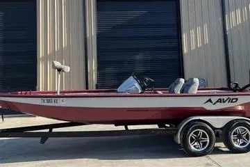 Slide: The Image of 2024 Avid 20 XB boat on trailer, parked outside a building. - 1