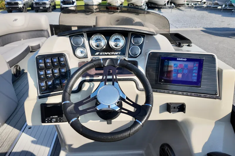 Slide: The Image of 2023 Starcraft CX 25 DL boat dashboard with steering wheel and Simrad display. - 12