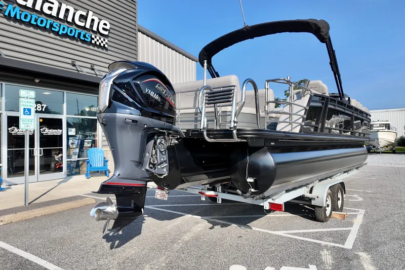 Slide: The Image of 2023 Starcraft CX 25 DL pontoon boat on trailer at dealership. - 1