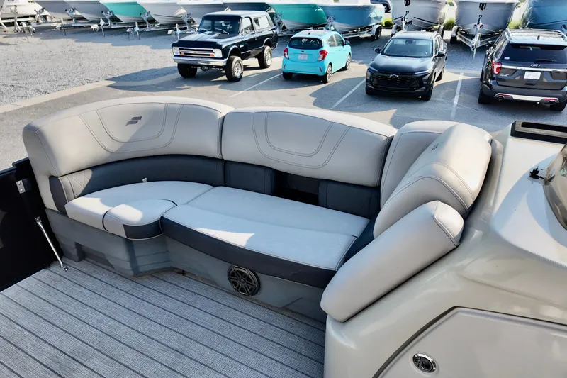 Slide: The Image of 2023 Starcraft CX 25 DL boat interior with plush seating in a parking lot. - 14