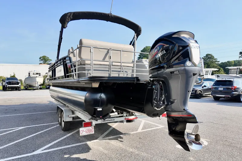 Slide: The Image of 2023 Starcraft CX 25 DL pontoon boat with Yamaha outboard motor on trailer. - 2