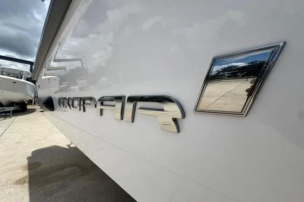 Slide: The Image of 2024 Axopar 37 Sun-Top boat exterior with chrome logo detail. - 8
