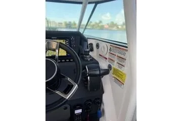 Slide: The Image of 2024 Axopar 37 Sun-Top boat cockpit with steering wheel and control panel. - 2