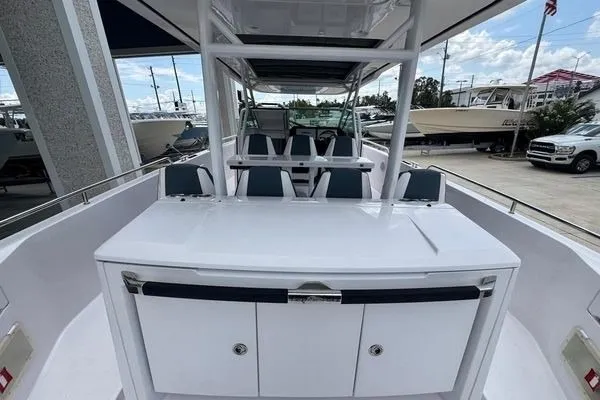 Slide: The Image of 2024 Axopar 37 Sun-Top boat interior with seating and storage, docked outdoors. - 10