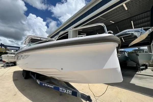 Slide: The Image of 2024 Axopar 37 Sun-Top boat on trailer under cloudy sky. - 11