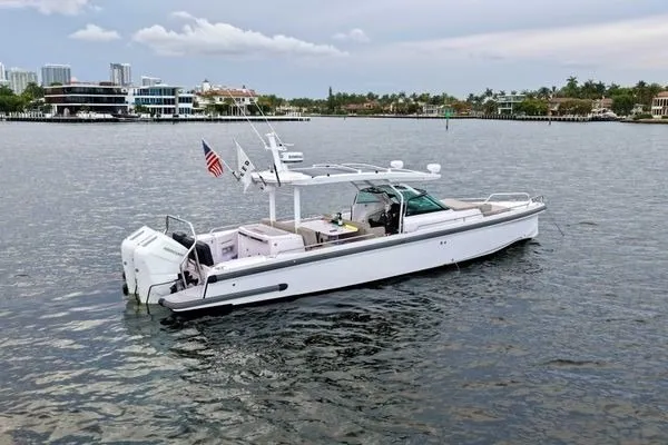 Slide: The Image of 2024 Axopar 37 Sun-Top boat on calm water, featuring sleek design and modern amenities. - 6