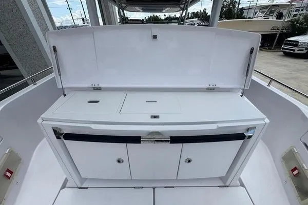 Slide: The Image of 2024 Axopar 37 Sun-Top boat interior with sleek white cabinetry and storage compartments. - 12