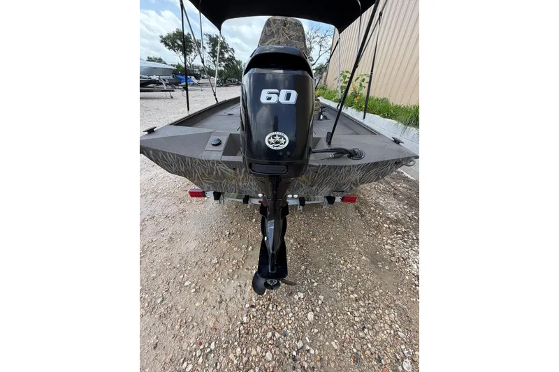Slide: The Image of 2024 Alweld 1856 Invader boat with 60 HP outboard motor, parked outdoors. - 18