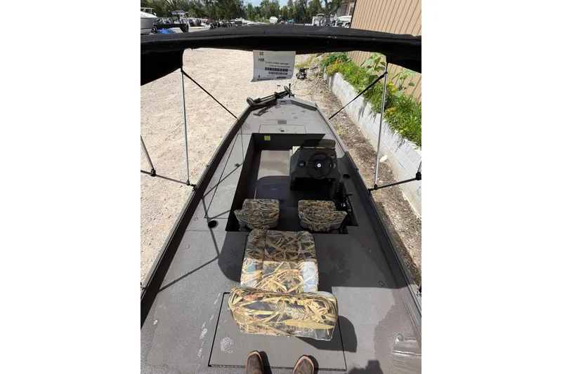 Slide: The Image of 2024 Alweld 1856 Invader boat interior with camouflage seating and steering console. - 9