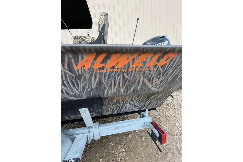 Slide: The Image of 2024 Alweld 1856 Invader boat with camouflage design and Suzuki motor. - 23