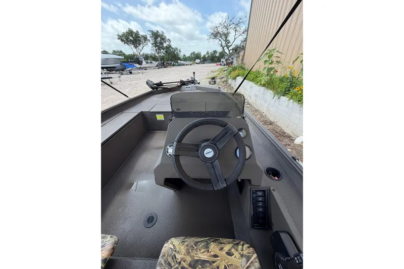 Slide: The Image of 2024 Alweld 1856 Invader boat interior with steering wheel and camo seating. - 15