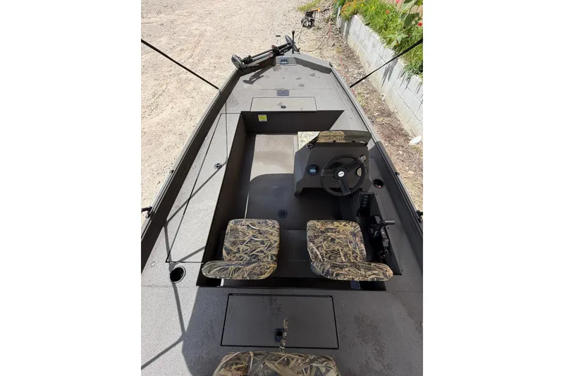 Slide: The Image of 2024 Alweld 1856 Invader boat interior with camouflage seats and steering console. - 10