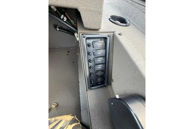 Slide: The Image of Control panel of 2024 Alweld 1856 Invader boat, featuring multiple switches and textured surface. - 13