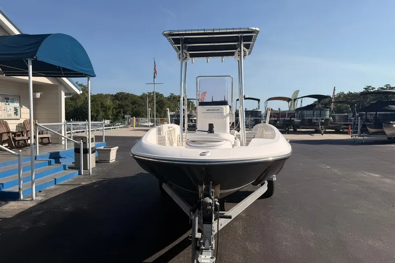 Slide: The Image of 2019 Bayliner Element F18 boat on trailer at marina under clear sky. - 2