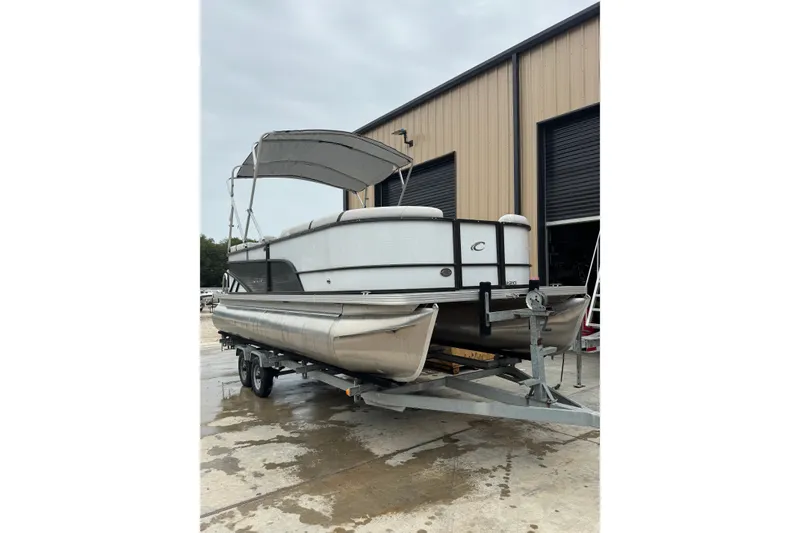 Slide: The Image of 2023 Crest 220 Classic LX pontoon boat on trailer near warehouse. - 3