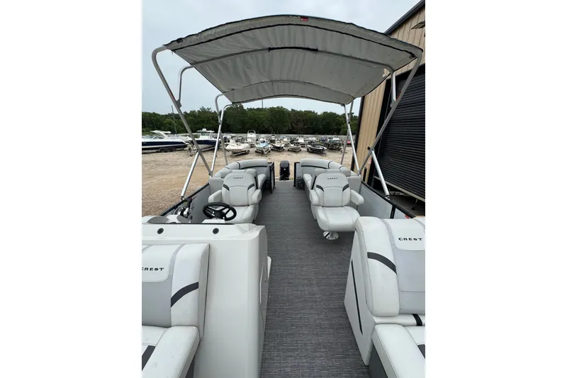 Slide: The Image of 2023 Crest 220 Classic LX pontoon boat with canopy and spacious seating. - 15