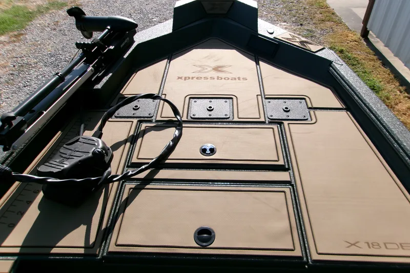 Slide: The Image of 2027 Xpress X18DB boat deck with storage compartments and trolling motor. - 18