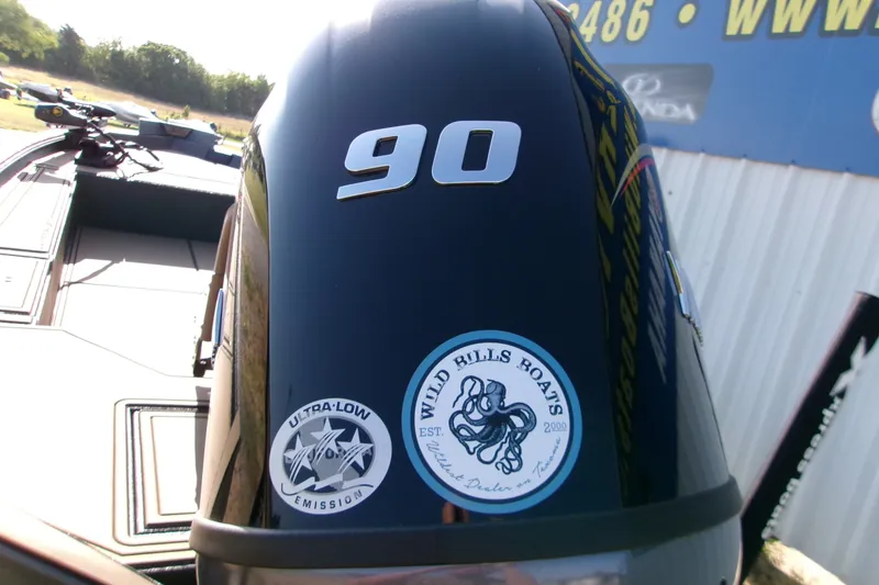 Slide: The Image of Outboard motor on Xpress X18DB boat, featuring "90" and "Ultra-Low Emission" stickers. - 3