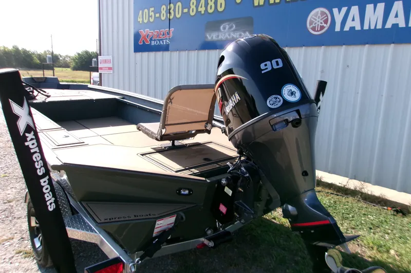 Slide: The Image of 2027 Xpress X18DB boat with Yamaha 90 engine, displayed outdoors near dealership. - 1