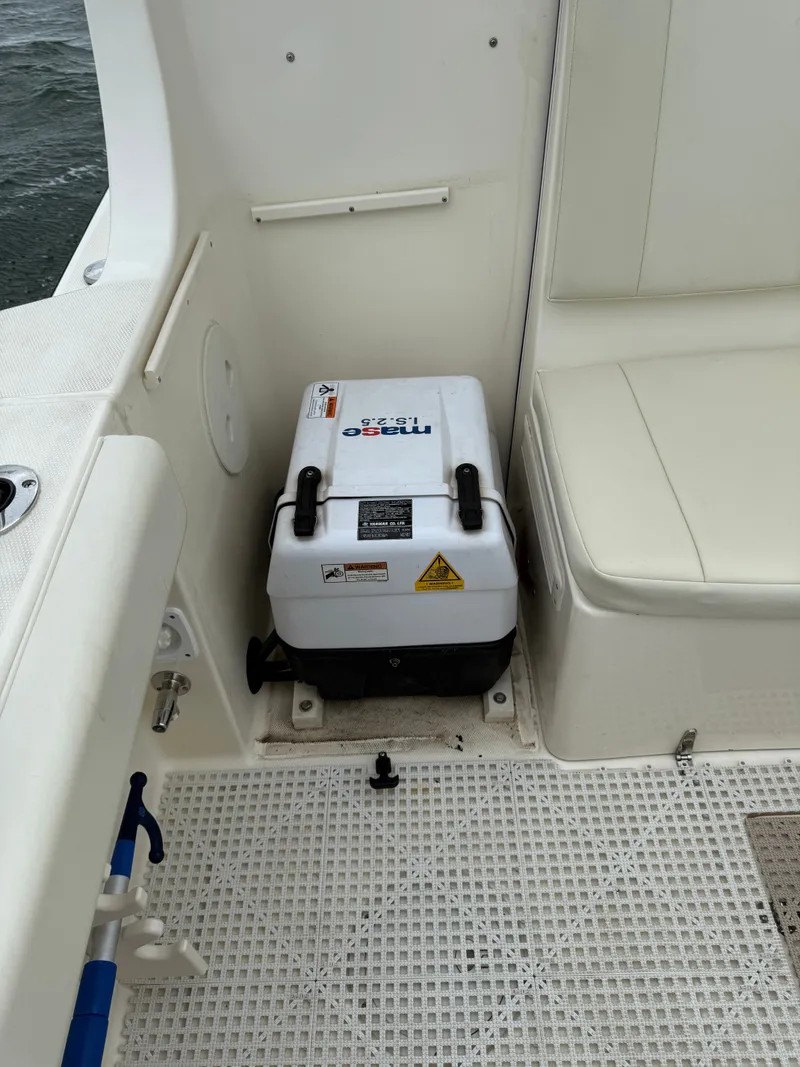 Slide: The Image of The image shows a boat interior with a white cooler and seating area. - 16