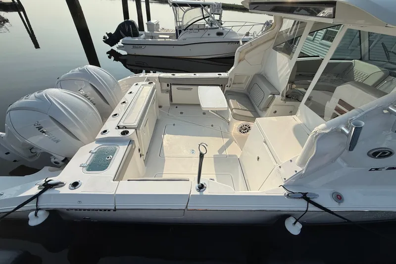Slide: The Image of 2026 Pursuit DC 326 Dual Console boat with twin Yamaha engines docked at marina. - 6