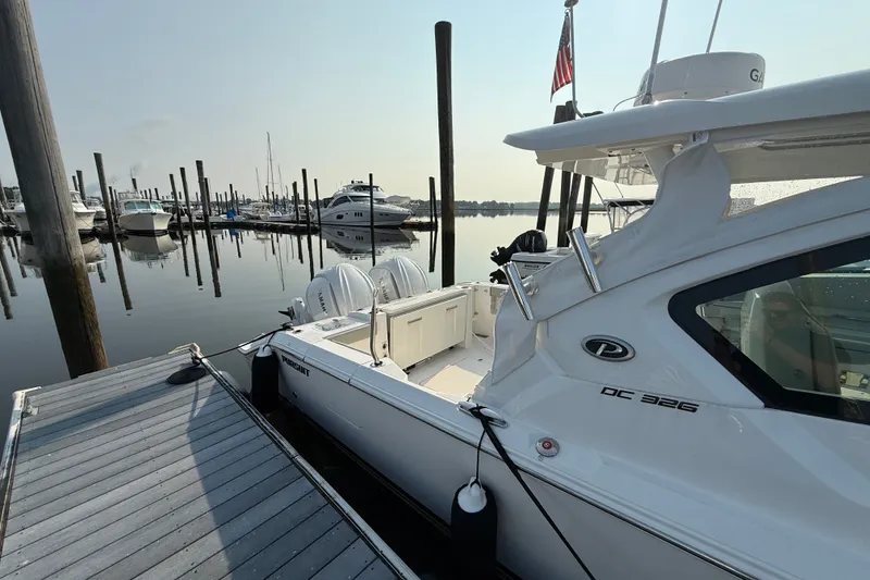 Slide: The Image of 2026 Pursuit DC 326 Dual Console docked at a marina with calm waters. - 3