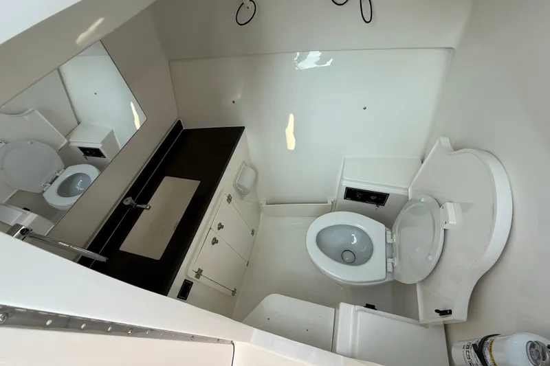 Slide: The Image of The image shows a modern boat bathroom with a toilet, sink, and mirror. - 16