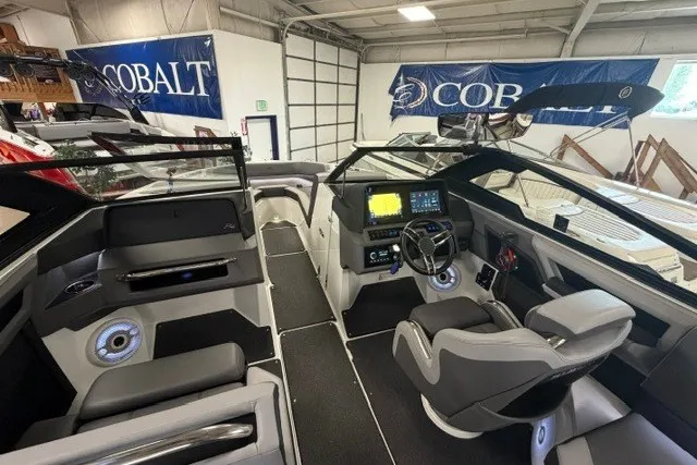 Slide: The Image of 2023 Cobalt R4 Surf boat interior with modern dashboard and seating in showroom. - 9