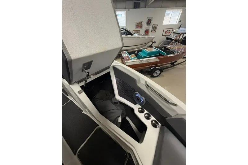 Slide: The Image of 2023 Cobalt R4 Surf boat interior with open storage compartment in showroom. - 11