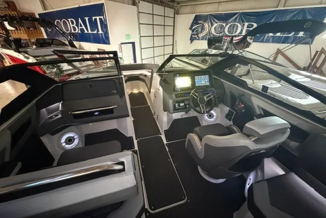 Slide: The Image of 2023 Cobalt R4 Surf boat interior with modern dashboard and seating in showroom. - 8