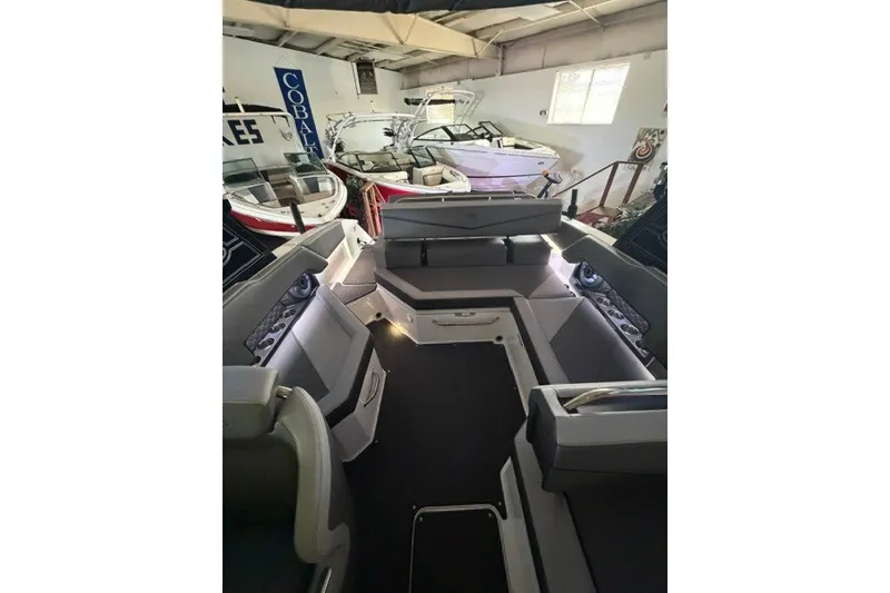 Slide: The Image of 2023 Cobalt R4 Surf boat interior in showroom with seating and modern design. - 7