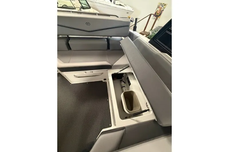 Slide: The Image of 2023 Cobalt R4 Surf boat interior with open storage compartment and seating. - 20