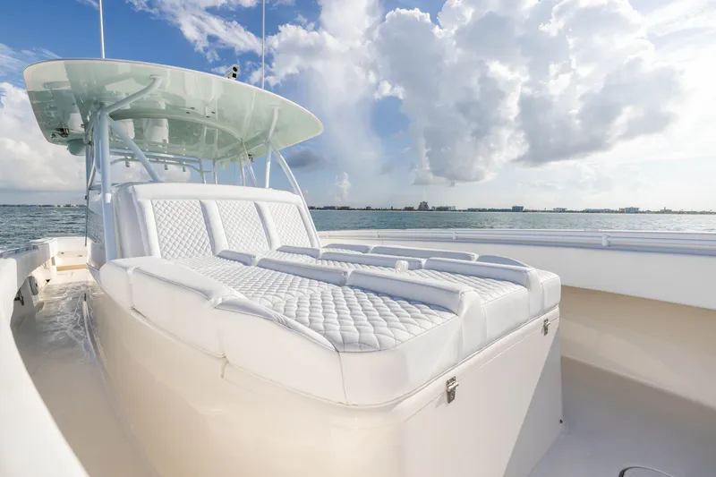 Slide: The Image of 2020 Contender 44 Fisharound boat with luxurious seating, ocean view, and cloudy sky. - 18