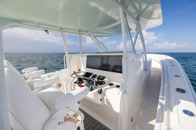 Slide: The Image of 2020 Contender 44 Fisharound boat cockpit with steering wheel and navigation screens. - 26
